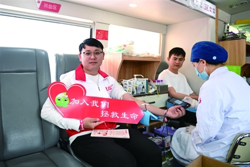青年志愿者在献血车上无偿献血 新华社发